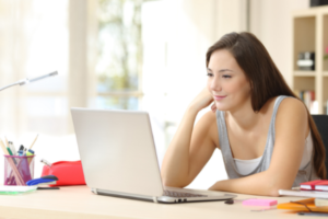 A young female student is studying on her laptop