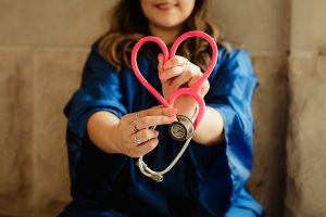 a Nurse is holding a stethoscope in a heart shape
