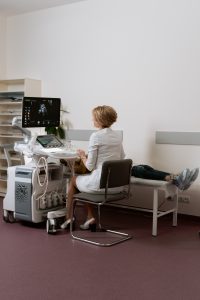 Diagnostic medical sonographer sitting at a computer