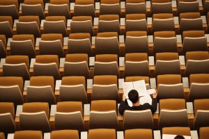 A person sitting in an auditorium by themselves