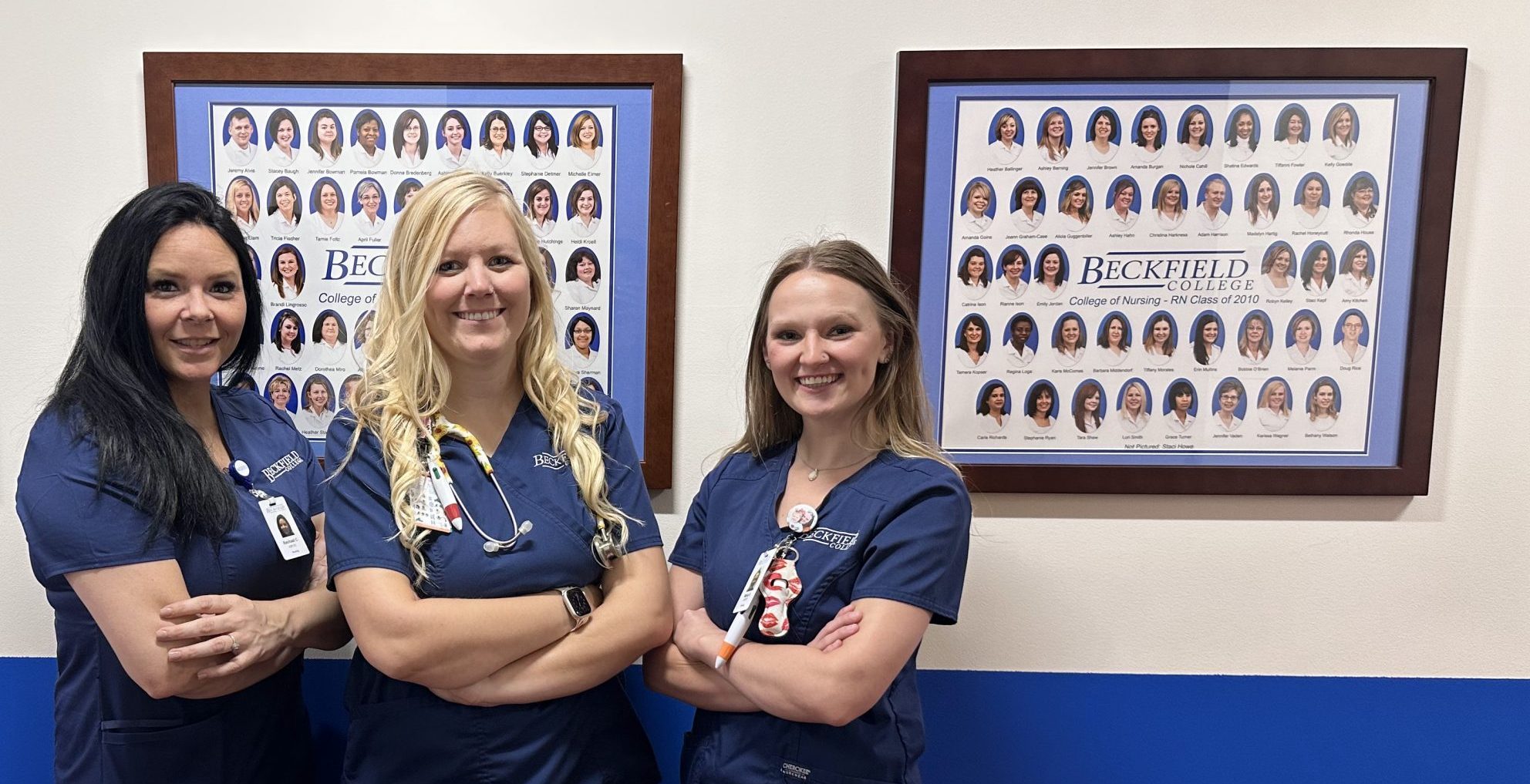 3 Nursing students at Beckfield campus looking at the graduation photos from years ago